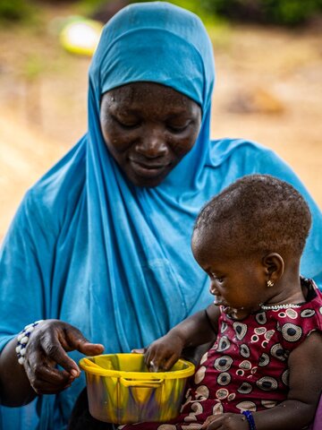 A 10-month-old girl puts her hand in the plate containing the fortified porridge to drink it by hand.

In the countries of the central Sahel (Burkina Faso, Mali and Niger), the food security and nutritional status of the population, and of women and children aged 6 to 23 months, is seriously compromised and worsening in a context of simultaneous crises linked to conflict, climate, Covid-19 and soaring food, fuel and fertilizer prices.
And to reduce malnutrition in this area of West Africa, the United Nations World Food Programme (WFP) - in collaboration with the European Union - has implemented in Burkina Faso, Mali and Niger, an innovative approach to improve nutrition by strengthening national food systems in unstable contexts to fill gaps in availability and affordability: the Food Systems in Crisis (CRIALCES) project.
In Kaya (Burkina Faso), WFP assists breastfeeding women affected by conflict and climate change with food vouchers to ensure that they and their children have access to a balanced and nutritious meal to prevent malnutrition.